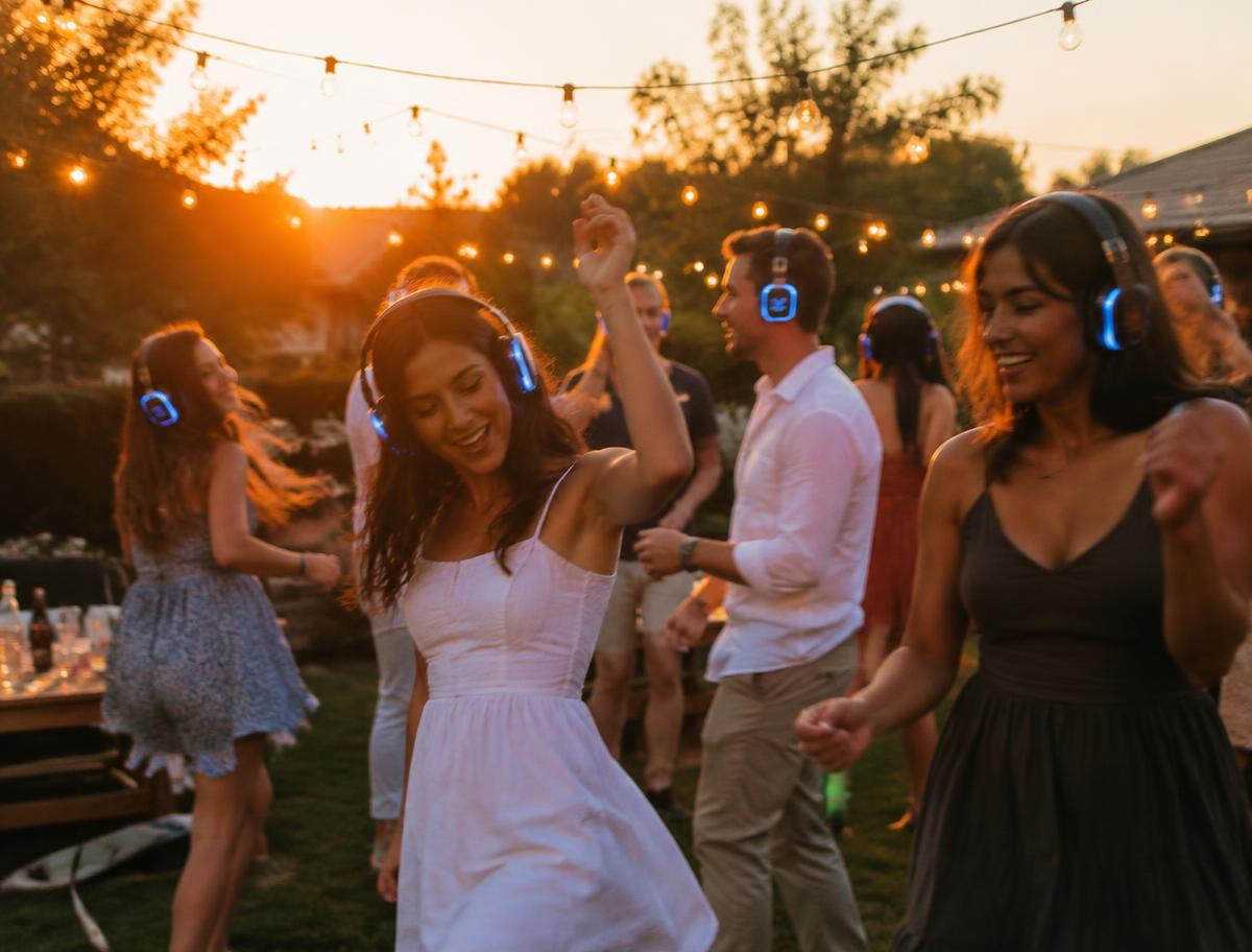 Guests dancing in a backyard wearing glowing headphones
